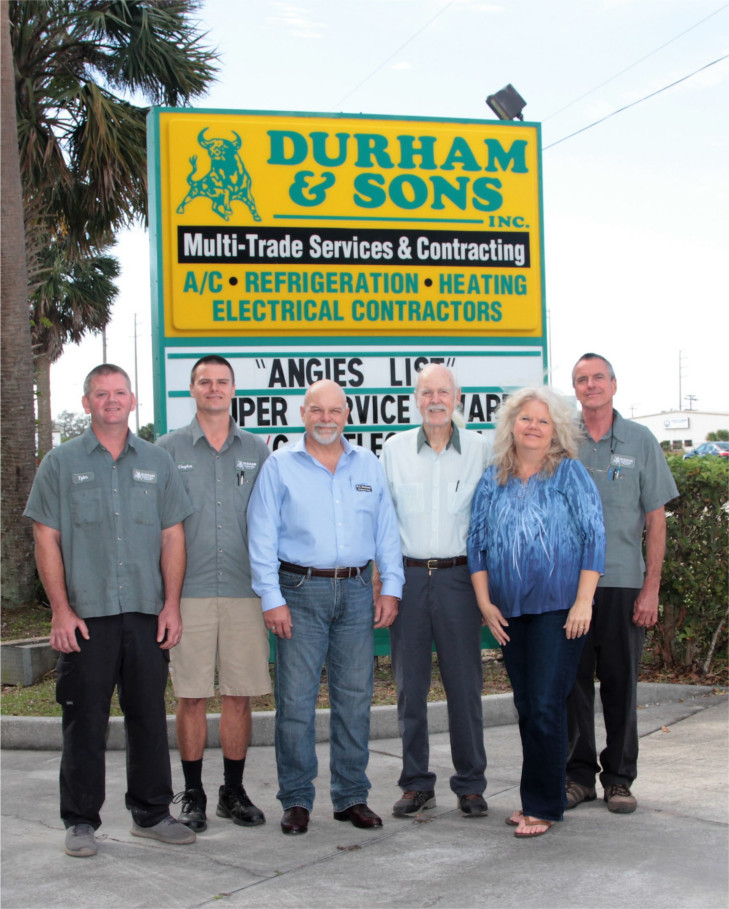The Durham family in front of the Durham & Sons sign in Melbourne